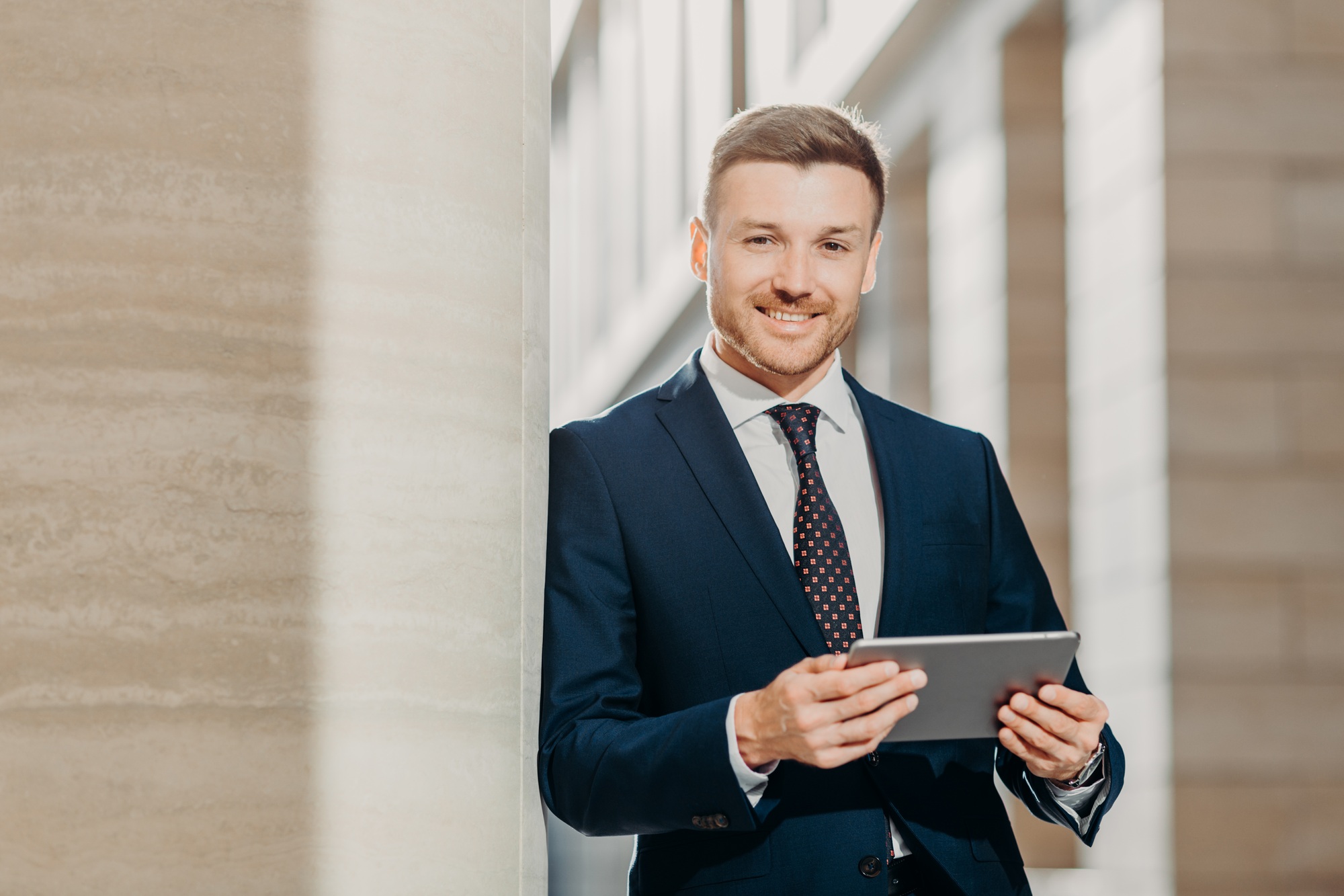 Businessman checks email or updates profile on digital tablet computer